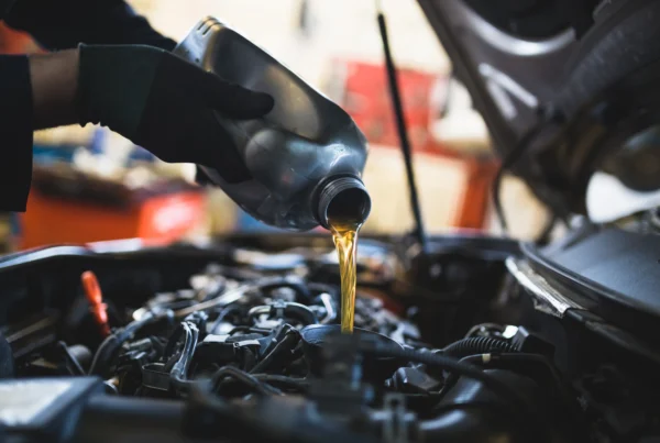 Fresh motor oil being poured into a car engine